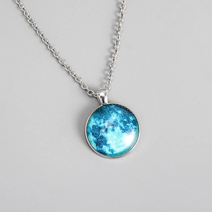 Macro view of blue galaxy moon pendant with clear glass dome and silver chain necklace