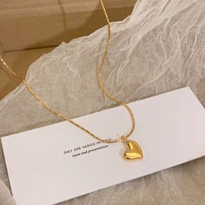 18k gold heart pendant necklace in stainless steel with polished finish on warm paper