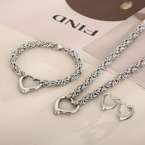 Detailed flat lay of silver heart-shaped stainless steel necklace bracelet and earring set
