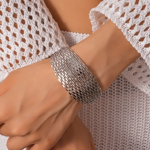 Close-up of silver geometric layered bracelet with faceted metal texture on model wrist