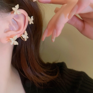 Detailed close-up of butterfly ear cuff set with rhinestones on a gold plated finish