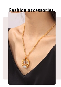 Detail of gold rope chain and bamboo pillar pendant with pavé set zircon stones