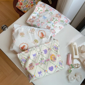 Detailed view of floral canvas makeup bags with zip closure and simple wish branding