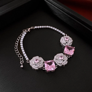 Macro detail of silver necklace with pink square gemstones and zircon flower accents