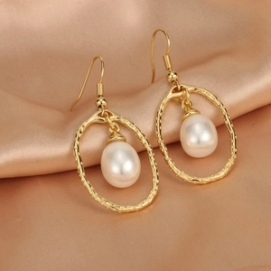 Macro shot of 18K gold-plated irregular oval earrings with teardrop freshwater pearl detail