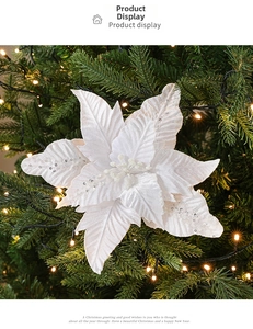 Fleur de poinsettia blanche pailletée avec sequins argentés sur branche de sapin de Noël
