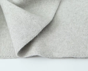 Close-up of light grey chunky knit cardigan showing soft wool blend fabric texture