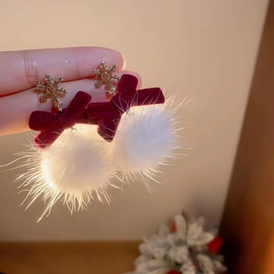 Detail of winter earrings with red velvet bow and white plush ball on snowflake stud