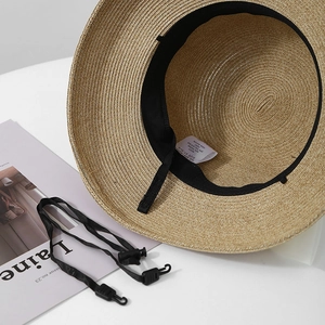 Close-up of straw sun hat interior with adjustable sweatband and detachable chin strap