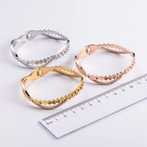 Detailed close-up of three crown-shaped bangles in gold, silver, and rose gold finish