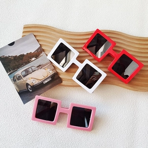 Three square frame sunglasses in red white and pink on a decorative wooden tray