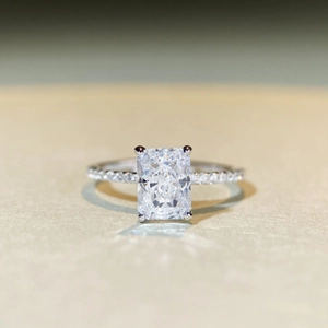 Macro shot of 2 carat radiant cut rectangle gemstone with pavé silver band detail