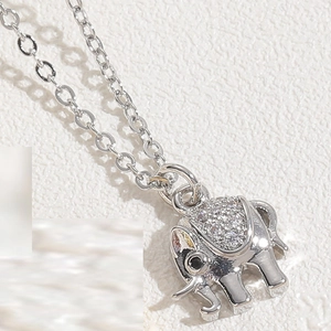Macro shot of silver elephant pendant with sparkling cubic zirconia and black gemstone eye