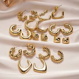 Détail de l'ensemble de 20 boucles d'oreilles géométriques dorées sur soie couleur champagne