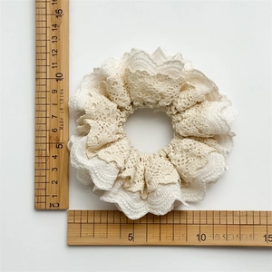 Lace ruffle scrunchie in cream white with tiered hollow embroidery measuring about 11cm
