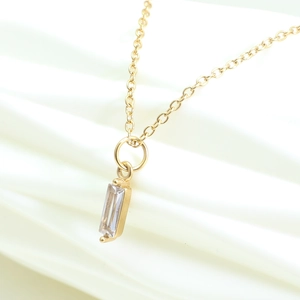Golden necklace featuring a rectangular zircon birthstone pendant on a fine chain link