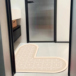 L-shaped beige absorbent bath mat with vintage patterns placed at a bathroom entrance