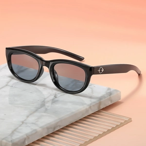 Vintage black cat-eye sunglasses with gradient lenses on white marble stone base