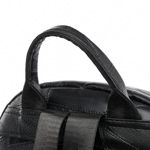 Detail of the black leather bag handle and strap attachment with lychee texture