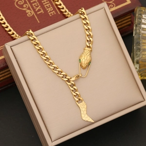 Golden snake head necklace with green gemstone eyes on a Cuban link chain style