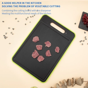 Detail of black defrosting cutting board with green border and built-in knife sharpener