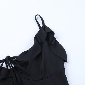 Detail of black evening dress featuring ruffled neckline and delicate spaghetti straps