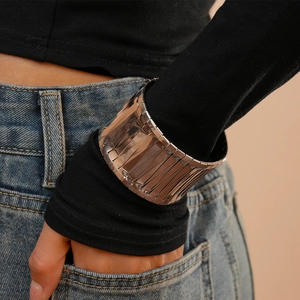 Detail of wide segmented silver cuff bracelet with mirror finish on woman's wrist