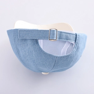 Dettaglio della fibbia in metallo regolabile e tessuto denim del cappello da bambino