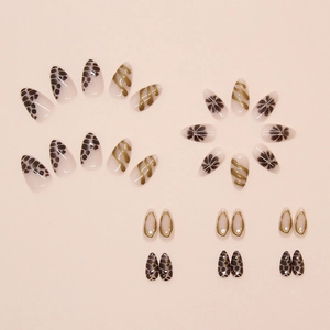 Detailed view of almond-shaped press-on nails with leopard print and gold swirl designs