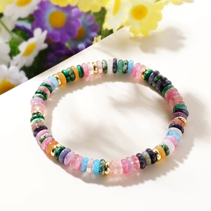 Macro detail of colorful disc bead bracelet with golden metal spacers on white background