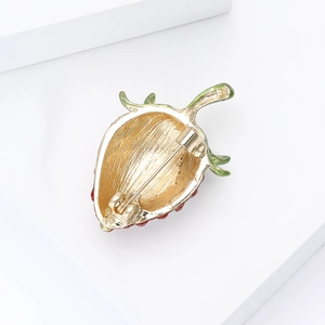 Detailed back view of a strawberry brooch showing gold alloy pin and colorful enamel work