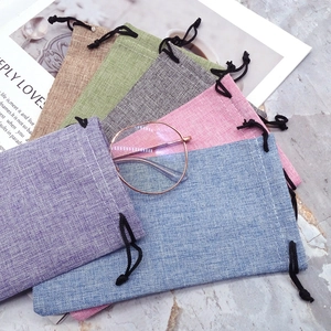 Linen drawstring pouches in multiple colors for sunglasses and jewelry storage on marble