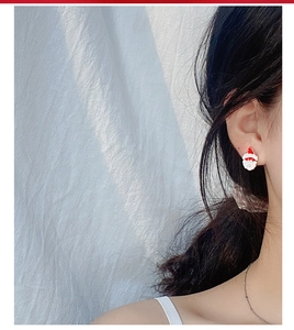 Detail of model wearing a cute red Santa Claus stud earring for Christmas gifts