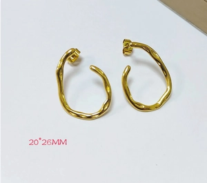 Macro detail of gold wavy earrings measuring 20x26mm with liquid metal texture finish