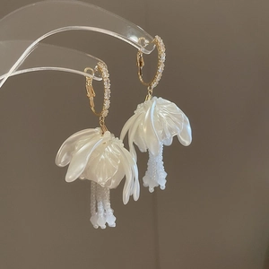 Elegante Gold-Ohrringe mit weißen Blütenblättern, Perlenfransen und Kristallbesatz