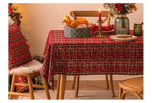Detail view of red and green plaid Christmas tablecloth with snowflake and gold accents