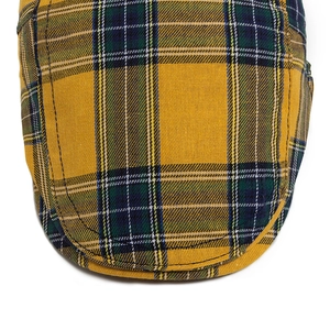 Retro plaid newsboy cap in yellow and green checkered pattern with stitch detail