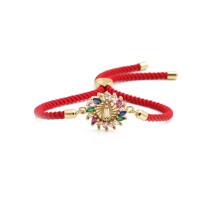 Red braided rope bracelet with colorful zircon Virgin Mary charm on white background