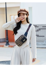 Close-up of leopard print fanny pack with adjustable strap worn as a crossbody bag