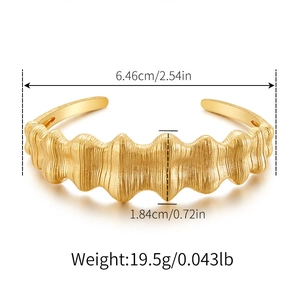 Detailed view of golden irregular wave bracelet with diameter and weight measurements