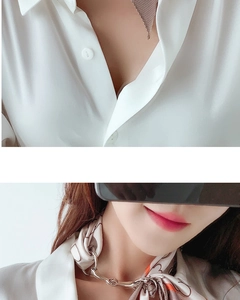 Detail view of a horsebit silk scarf buckle ring shown on a patterned scarf and shirt