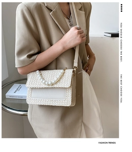 Close-up of pearl handle and woven texture on a cream crossbody straw bag for women