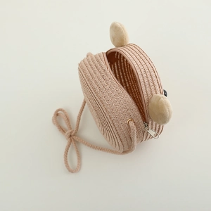 Détail d'un sac bandoulière en paille pour enfant avec oreilles d'ours et fermeture éclair
