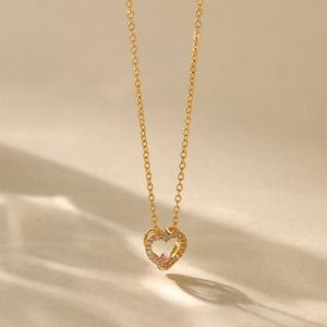 Macro shot of 18K gold plated heart pendant with pink zircon and white stone halo