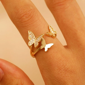 Macro shot of three golden butterflies ring with pave zircon stones on female hand