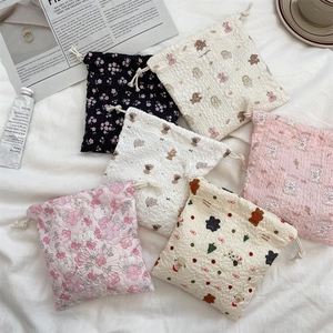 Detailed view of quilted seersucker drawstring bags with cute animal and floral prints