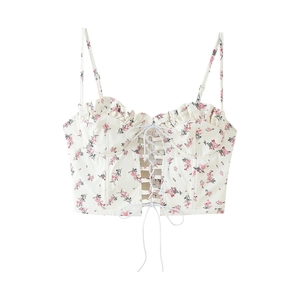 Close-up of white floral corset top with pink prints, lace-up detail and ruffled edges
