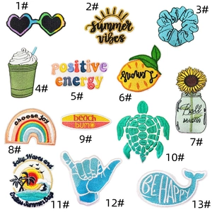 Detail view of 13 colorful summer-themed embroidered iron-on patches with neat edges