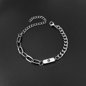 Detail of sun engraved rectangular plate on asymmetrical stainless steel couple bracelet