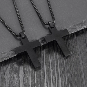 Minimalist black stainless steel double cross pendant necklace for men on stone background